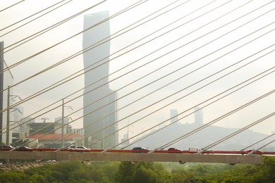 Photo of View of cars on bridge against foggy cityscape