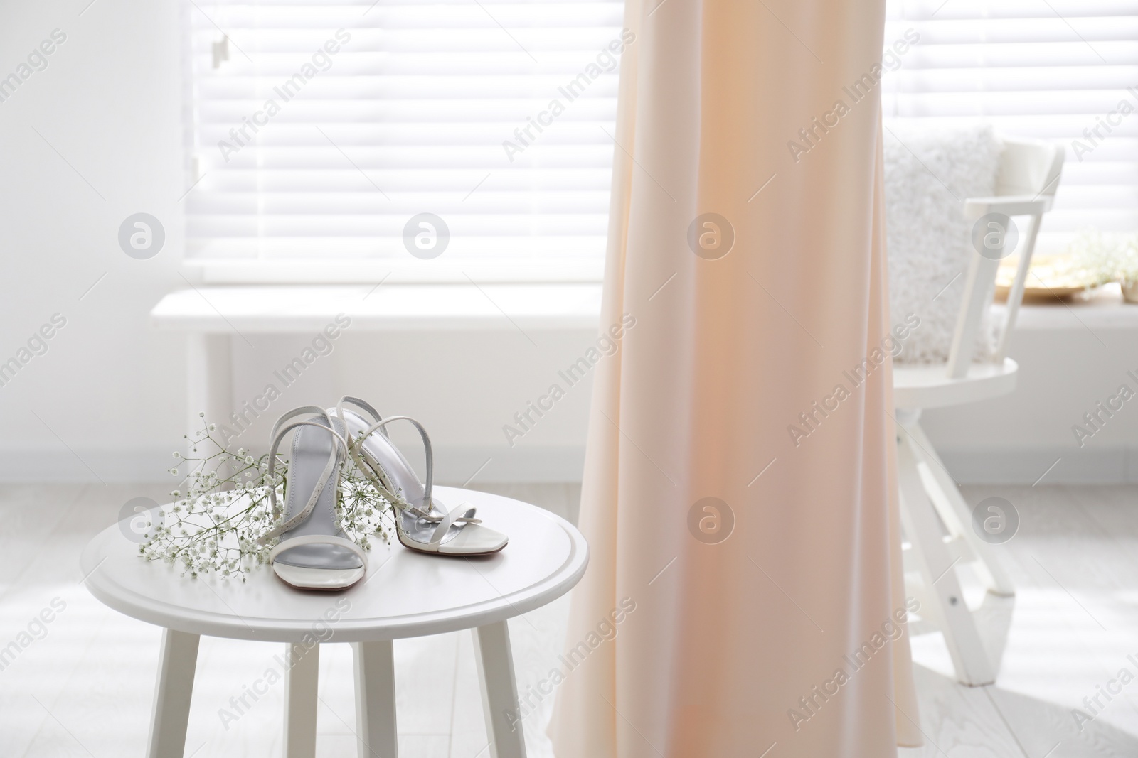 Photo of Beautiful wedding dress, shoes and flowers in room
