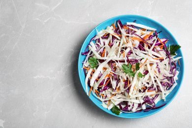 Photo of Tasty salad with cabbage on light grey marble table, top view. Space for text