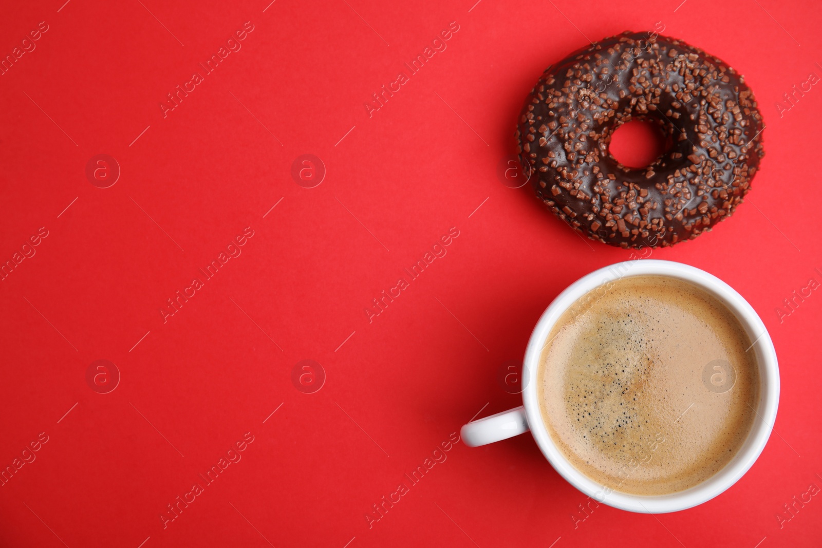 Photo of Delicious coffee and donut on red background, top view with space for text. Sweet pastries