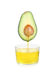 Photo of Essential oil dripping from cut avocado into bowl on white background