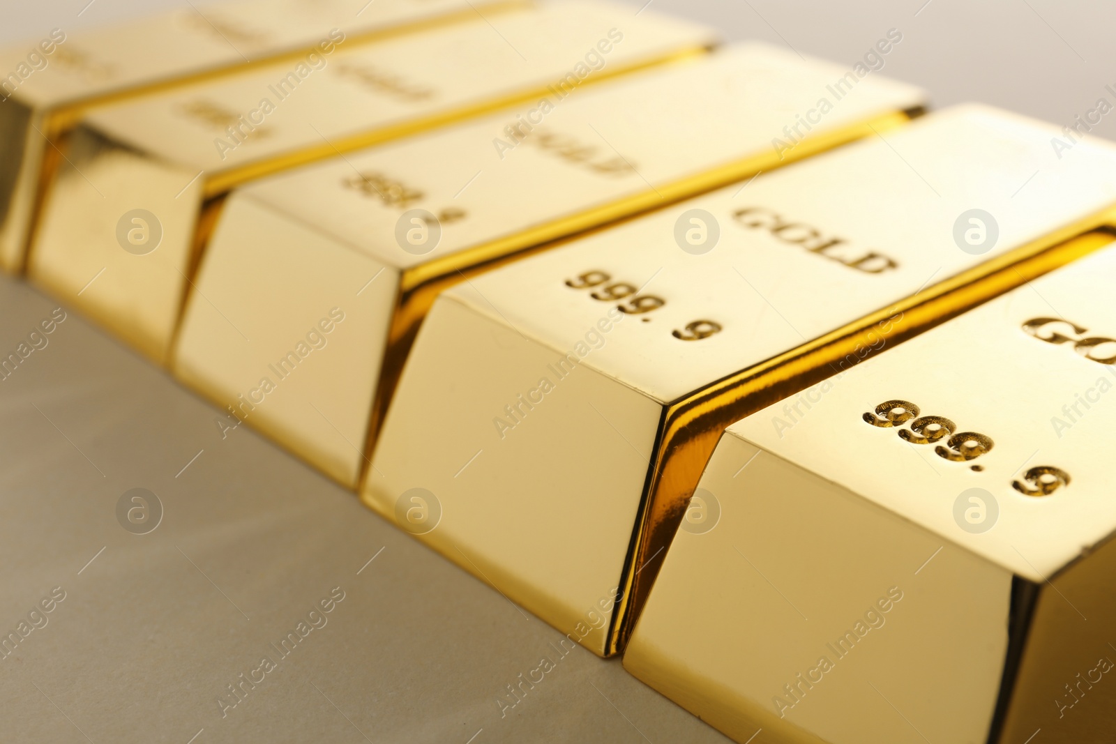 Photo of Precious shiny gold bars on light background, closeup