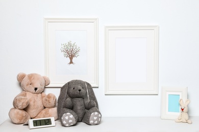 Photo of Composition with soft toys and photo frame on white background. Child room interior decor