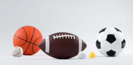 Photo of Many different sports balls on light gray background, space for text. Banner design