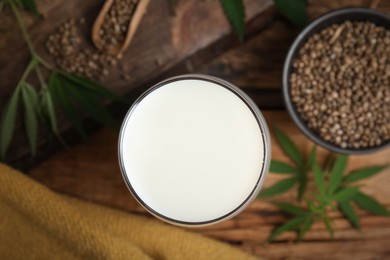 Glass of fresh hemp milk on wooden table, top view