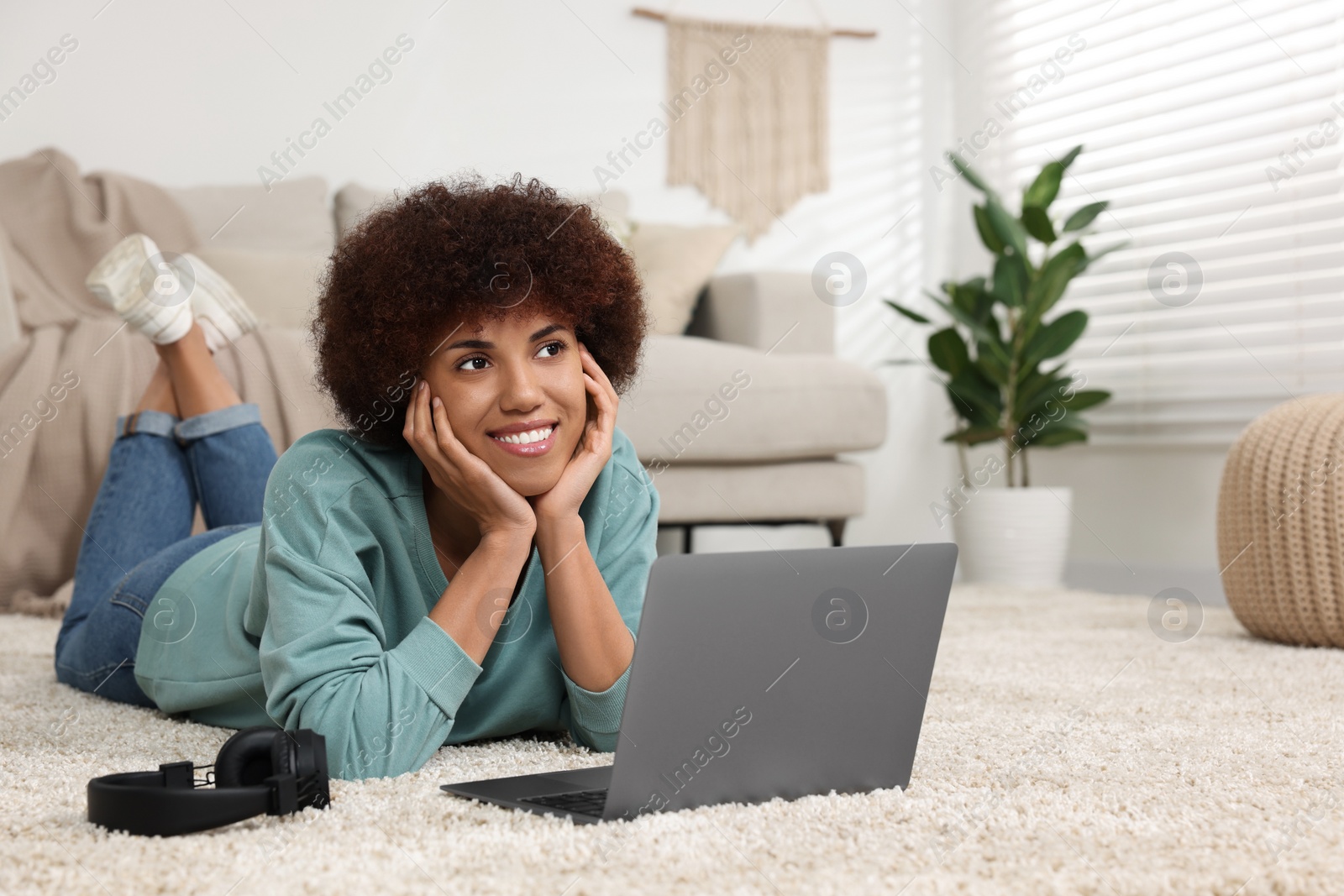 Photo of Beautiful young woman using laptop in room