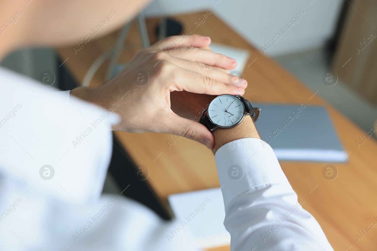 Photo of Man checking time in office, closeup. Being late