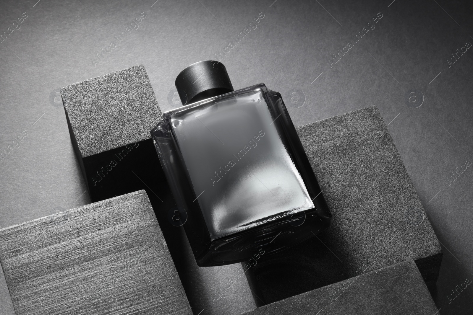 Photo of Stylish presentation of luxury men`s perfume in bottle on black background, above view