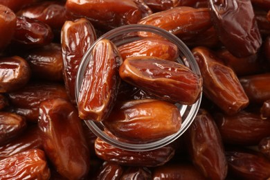 Tasty sweet dried dates and glass bowl, top view