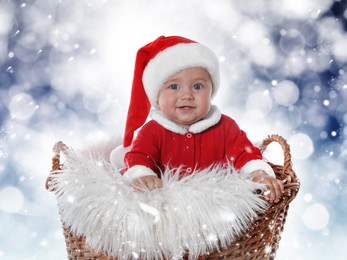 Image of Cute baby in wicker basket against blurred lights. Christmas celebration