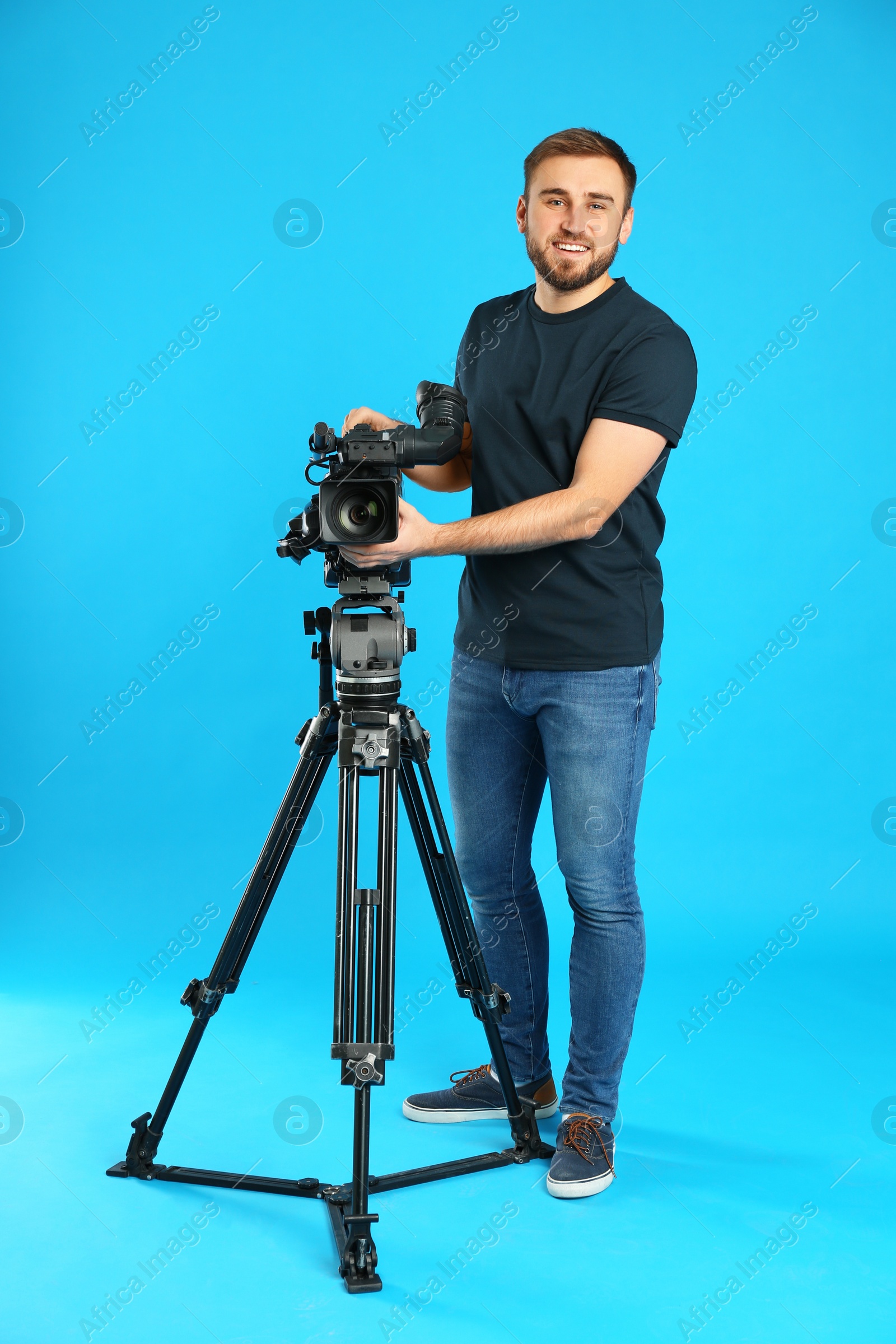 Photo of Operator with professional video camera on blue background