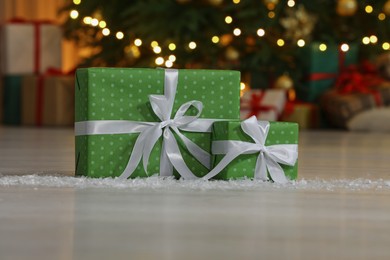 Photo of Gift boxes on floor near Christmas tree in room