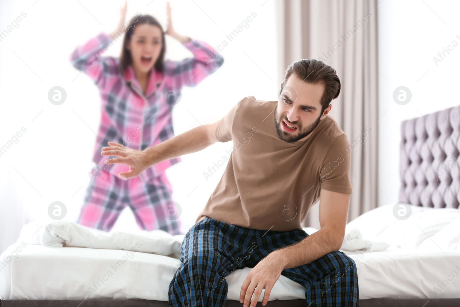 Photo of Young couple having argument in bedroom