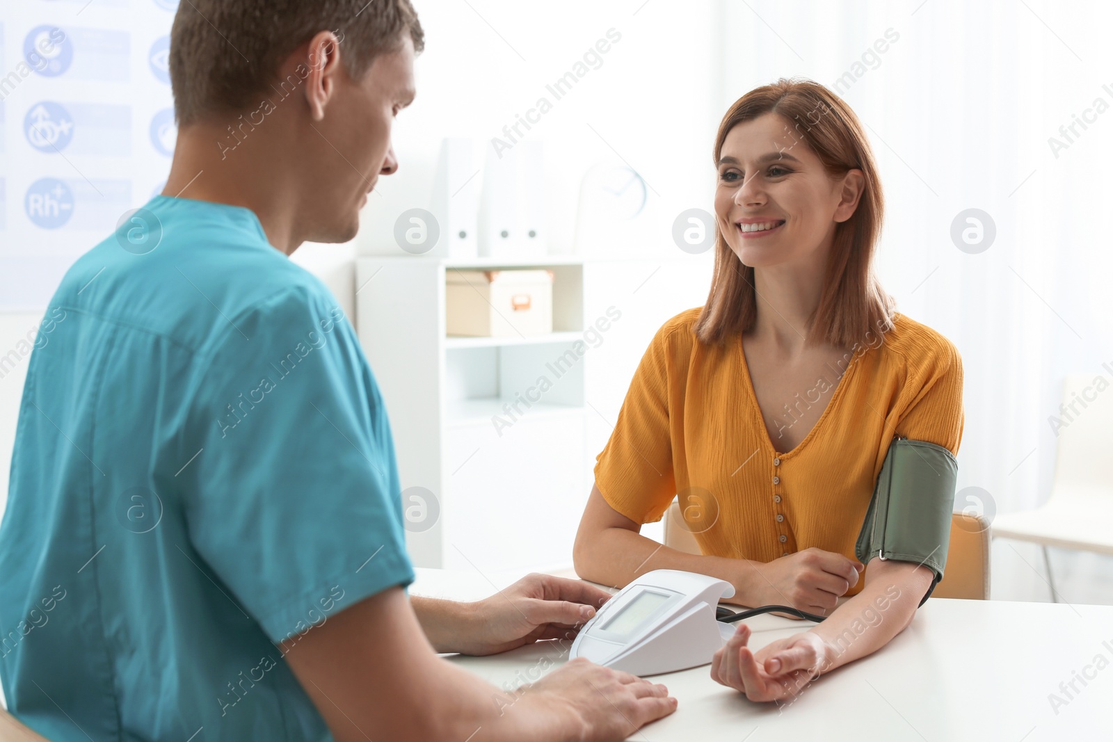 Photo of Doctor checking patient's blood pressure in hospital. Cardiology concept