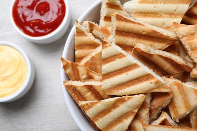 Photo of Delicious pita chips on white wooden table, closeup