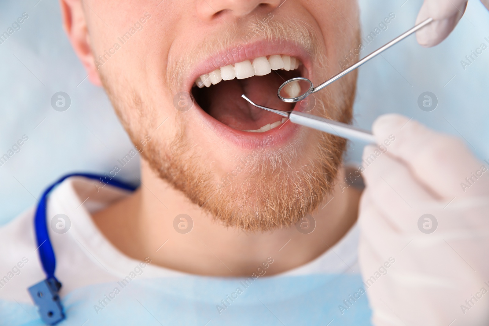 Photo of Dentist examining patient's teeth in modern clinic, closeup