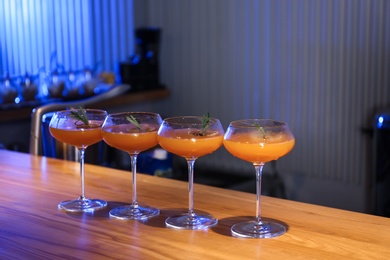 Glasses of delicious cocktail with vodka on wooden counter in bar