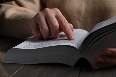 Photo of Woman with Bible at wooden table, closeup