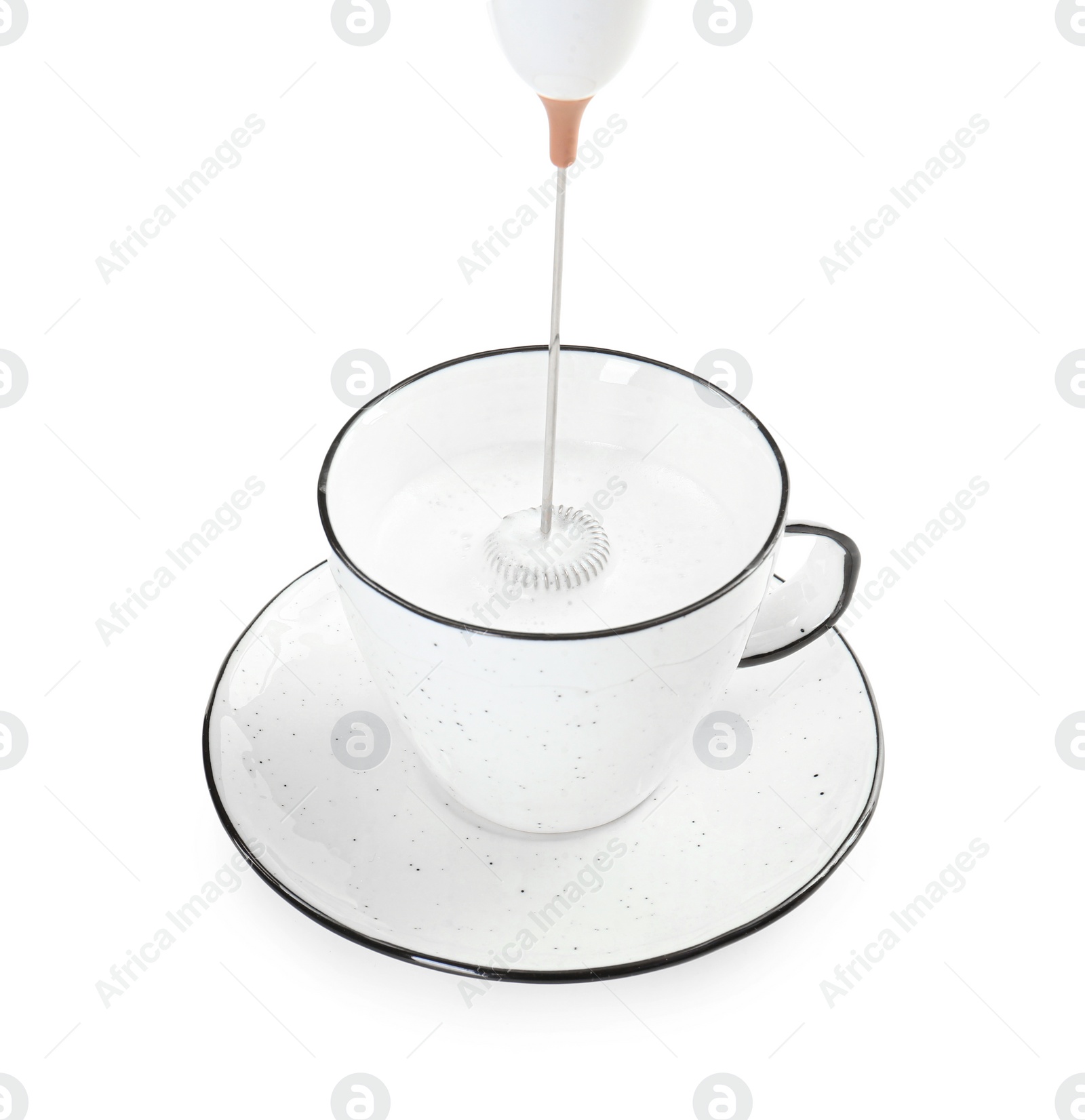 Photo of Whisking milk in cup with mini mixer (frother wand) isolated on white