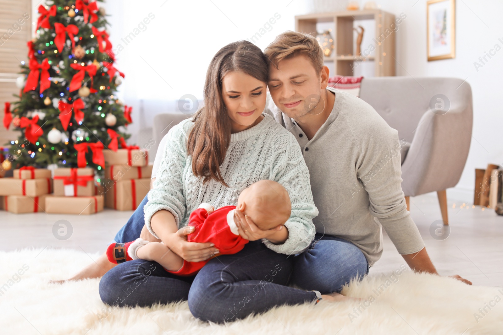 Photo of Happy couple with baby celebrating Christmas together at home