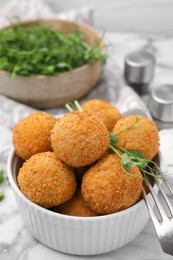 Photo of Bowl of delicious fried tofu balls with pea sprouts on white marble table, closeup