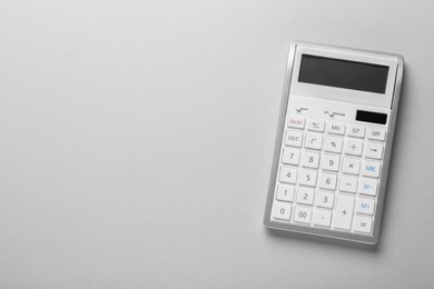 White calculator on light background, top view. Space for text