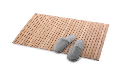 Photo of Bamboo rug with soft slippers isolated on white. Bath accessory
