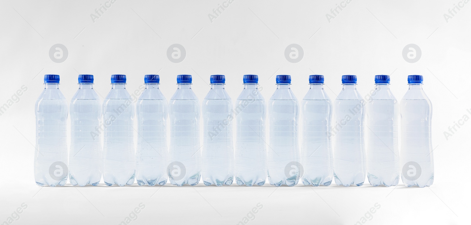 Photo of Plastic bottles with pure water on white background