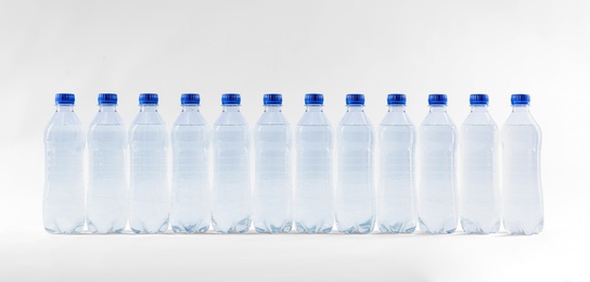 Photo of Plastic bottles with pure water on white background