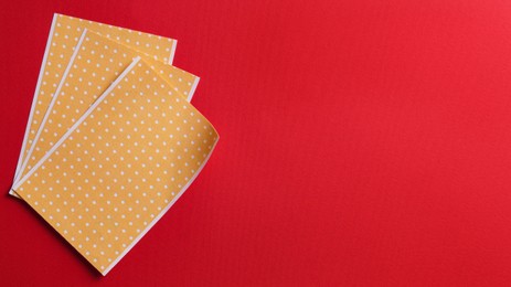 Pepper plasters on red background, flat lay. Space for text