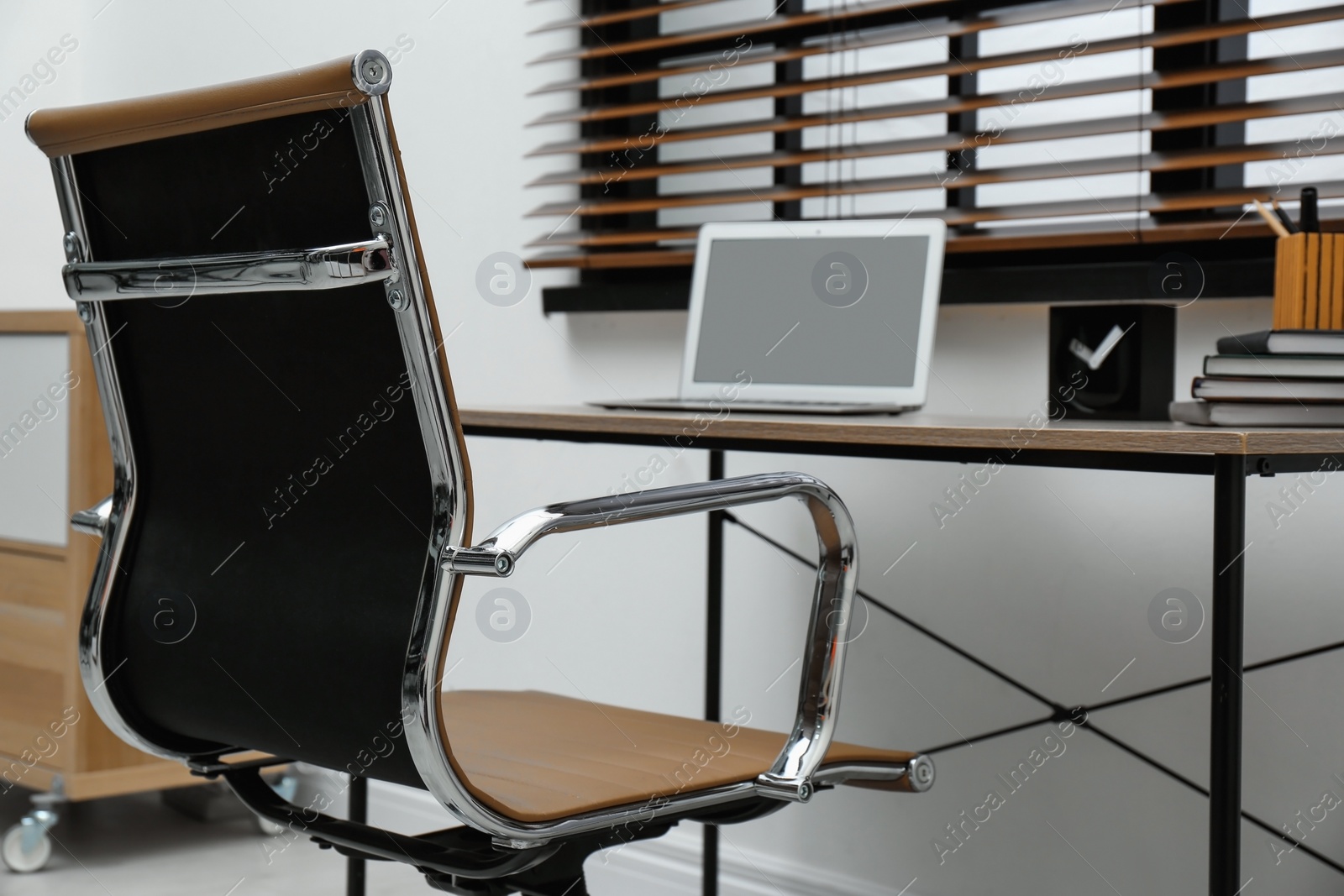 Photo of Stylish workplace interior with modern office chair