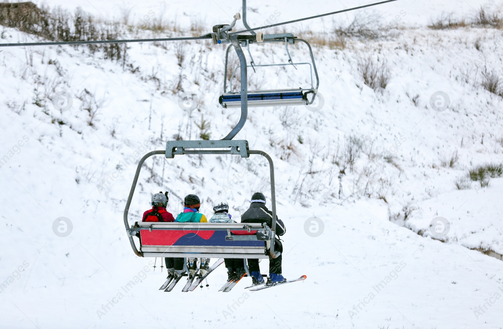 Photo of Chairlift with people at ski resort. Winter vacation