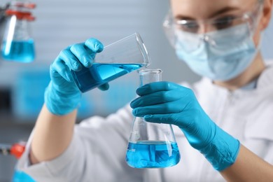 Scientist pouring sample into flask in laboratory, selective focus