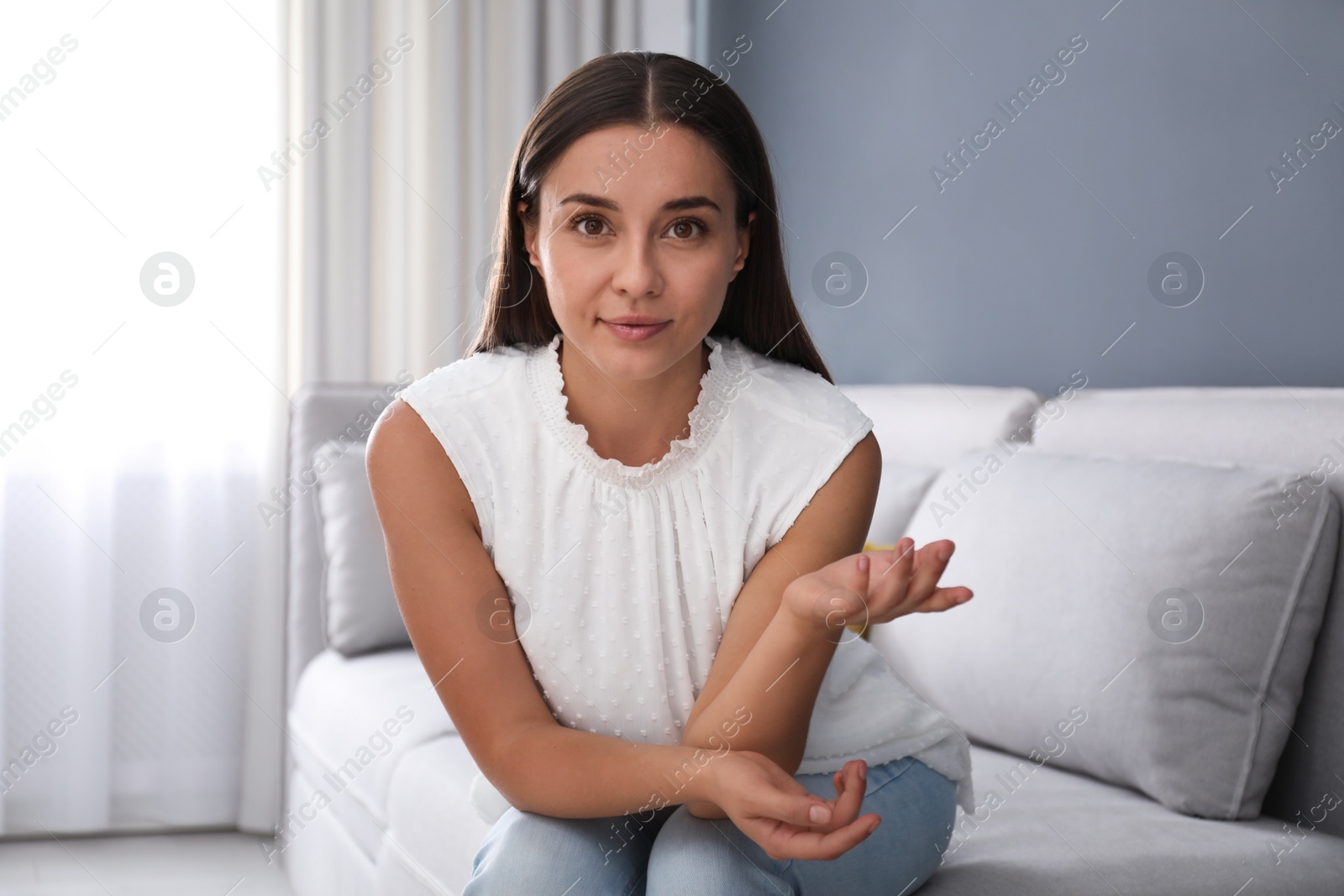 Photo of Young woman talking to his coworkers through video conference indoors, view from webcam