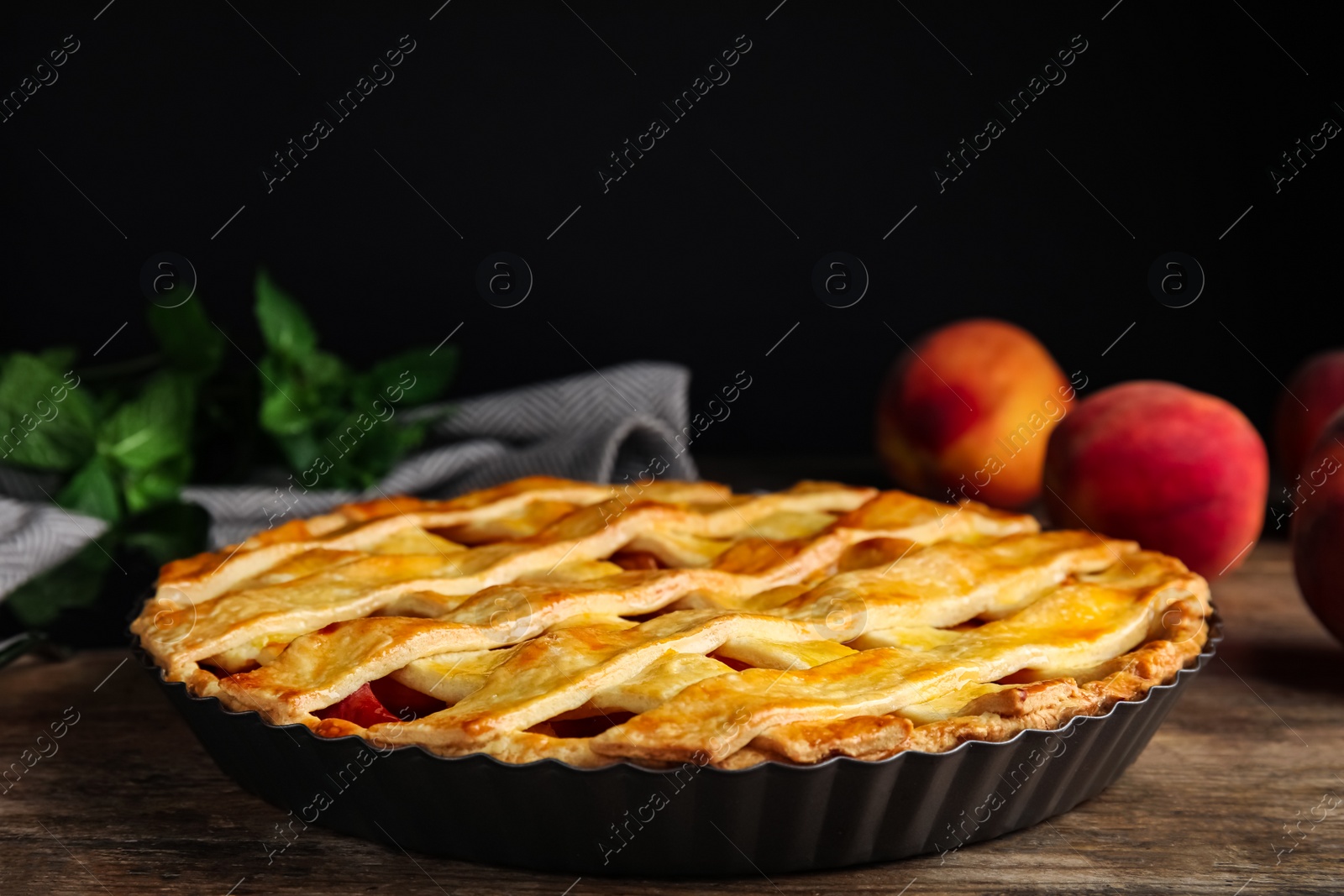 Photo of Delicious peach pie and fresh fruits on wooden table, closeup