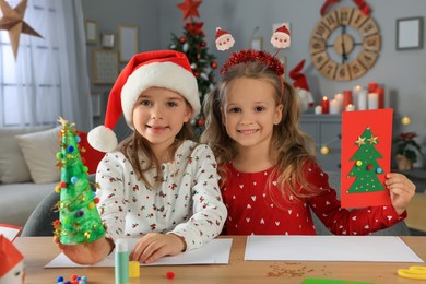Photo of Cute little children making beautiful Christmas greeting cards at home