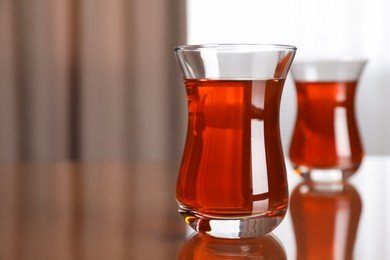Photo of Glasses with tasty Turkish tea on brown table indoors, space for text