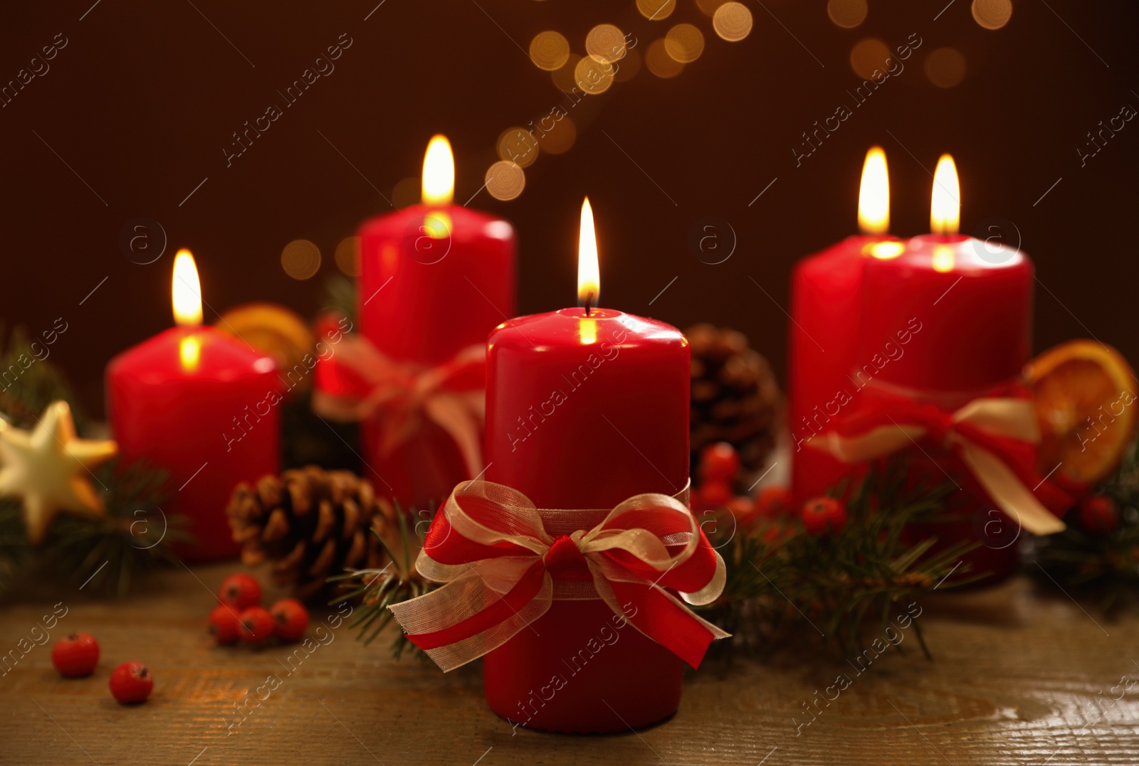 Photo of Beautiful Christmas composition with burning candle on wooden table against blurred lights