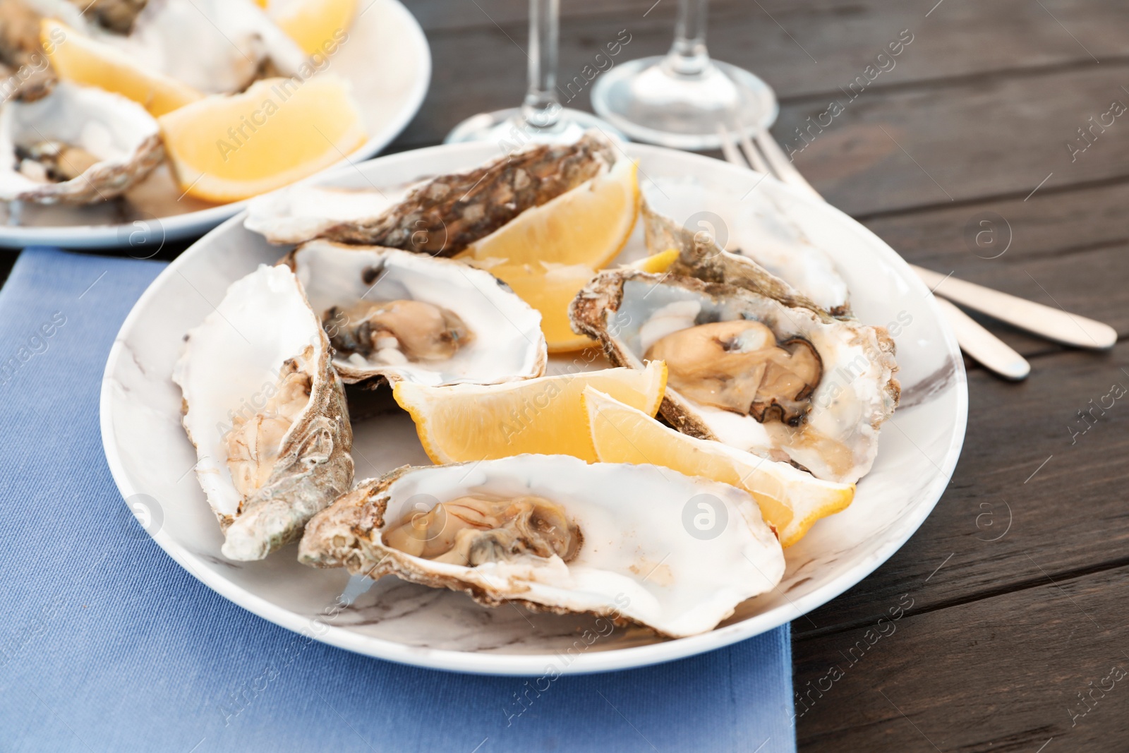 Photo of Fresh oysters with cut juicy lemon served on table