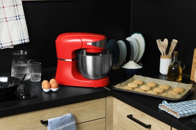 Modern stand mixer, ingredients, tableware and baked cookies on countertop in kitchen