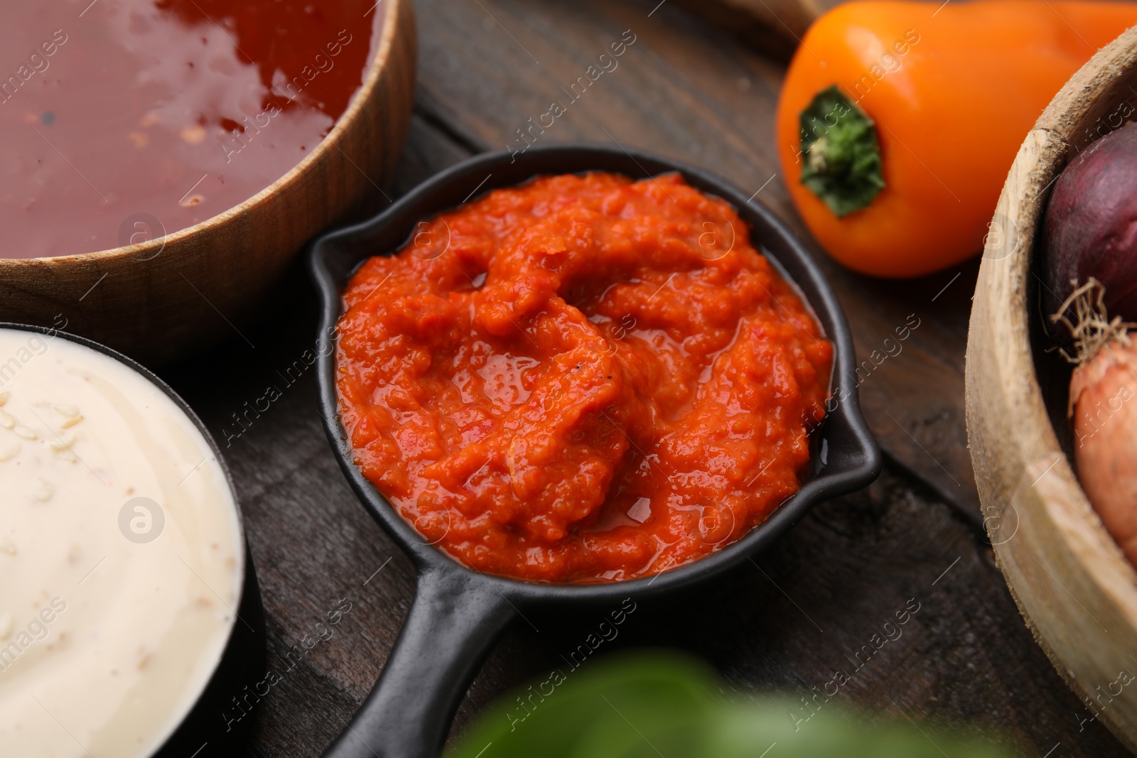 Photo of Homemade marinade in sauce pan on wooden table, closeup