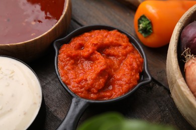 Photo of Homemade marinade in sauce pan on wooden table, closeup