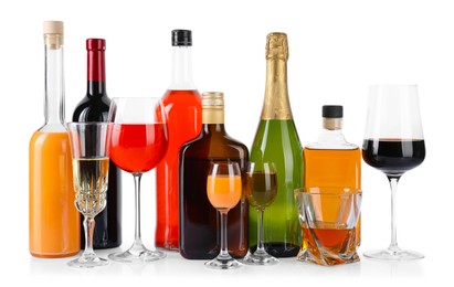 Photo of Bottles and glasses with different alcoholic drinks isolated on white