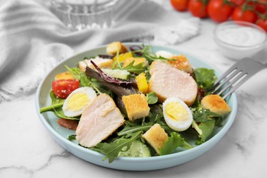 Photo of Delicious salad with croutons, chicken and eggs served on white marble table