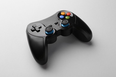 Photo of Black wireless game controller on light grey background