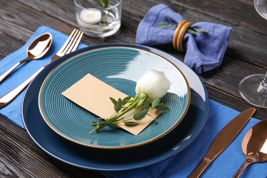 Photo of Elegant festive table setting with blank card on black wooden background