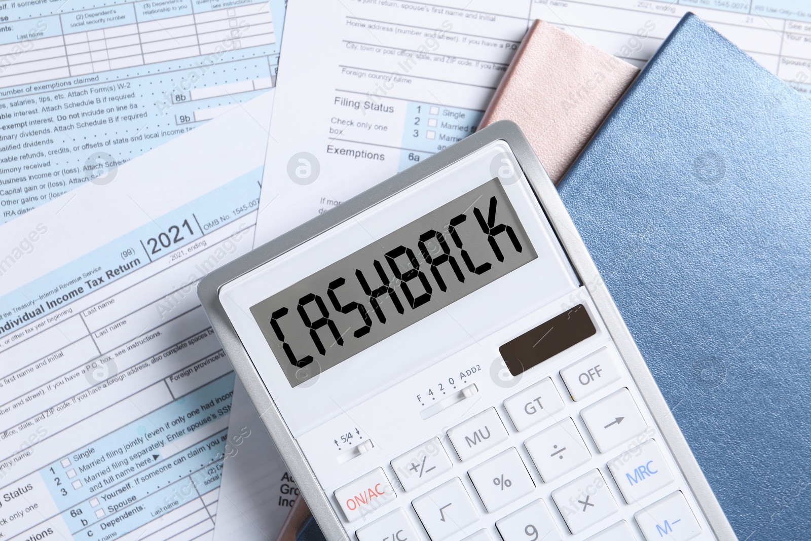 Image of Calculator with word Cashback and notebooks on documents, top view