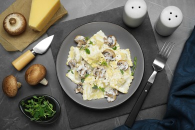 Delicious ravioli with ingredients on black table, flat lay