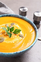 Bowl with tasty pumpkin soup on table, closeup