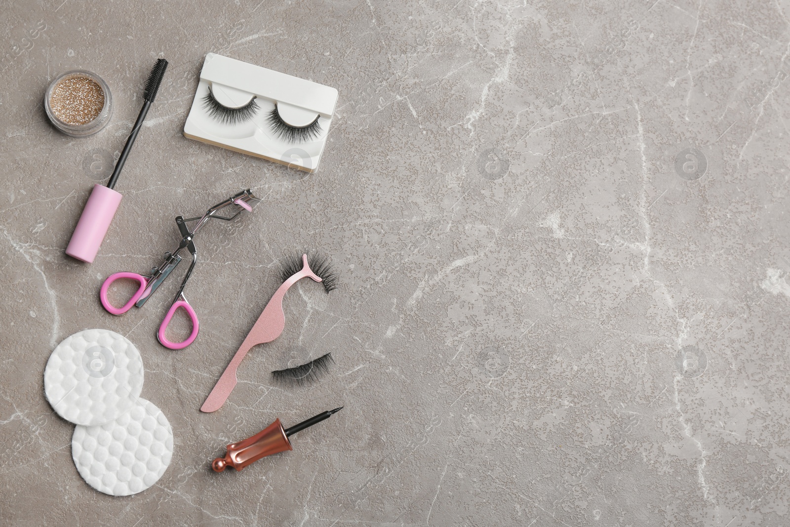 Photo of Flat lay composition with magnetic eyelashes and accessories on grey table. Space for text